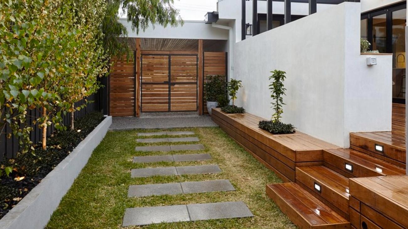 Garden area with glass, walls and trees.