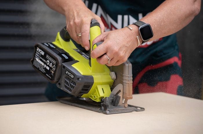 A Bunnings Team Member using a circular saw to cut wood