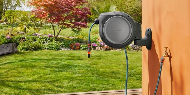 Gardena hose reel attached to wall in garden