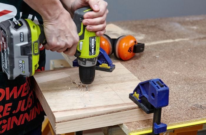 Holes being cut into the coat rack base for anchoring screws