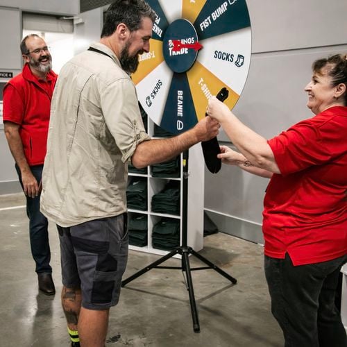 Bunnings team members playing a spinning wheel game with a customer