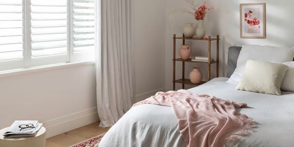 A cosy bedroom in a warm healthy home with a throw and rug