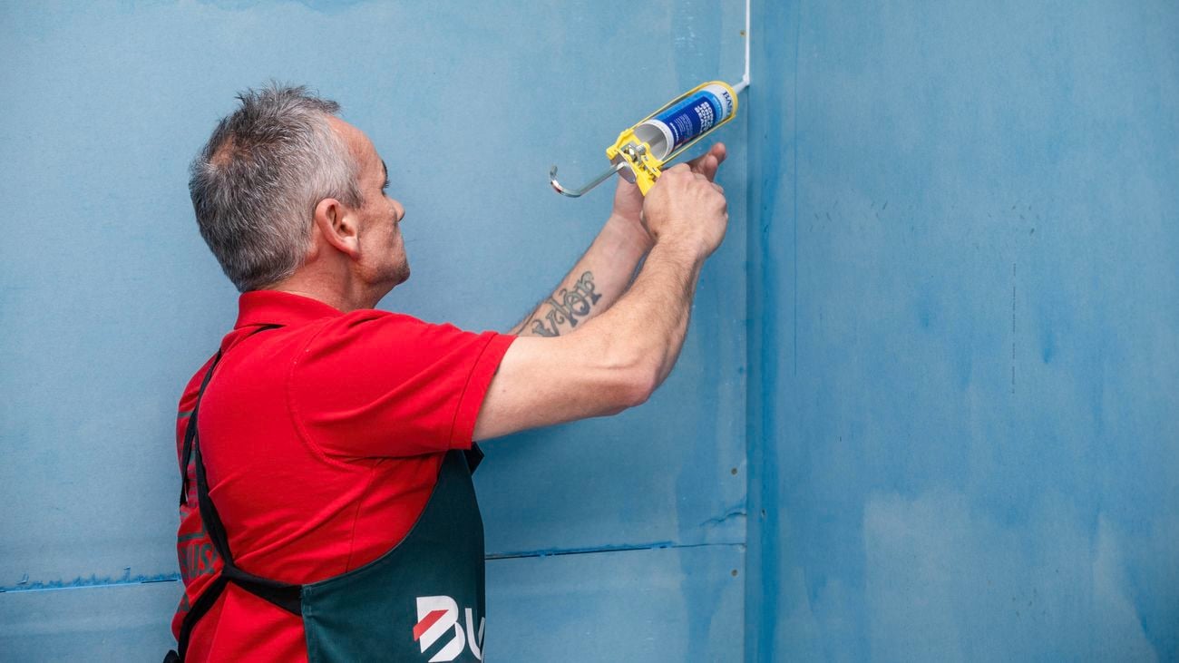 Bunnings team member applying sealer bond in a corner of a room