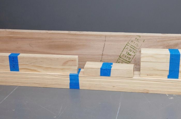 Slats of timber in various lengths lying on the floor.
