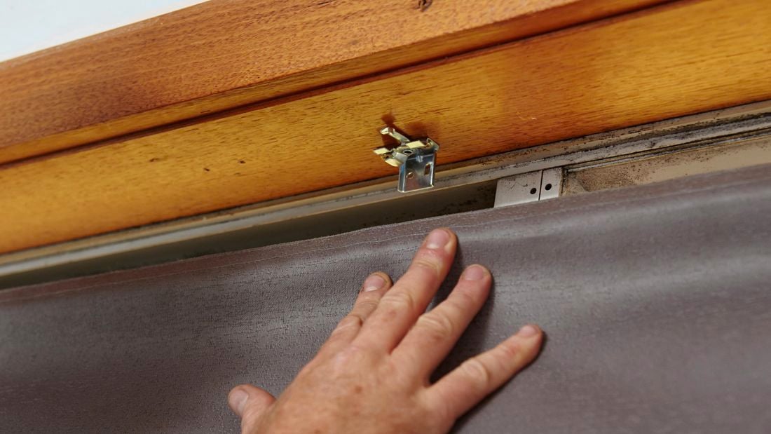 Person hanging roman blind.