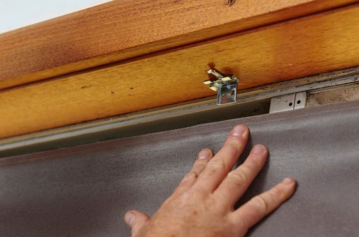 Person hanging roman blind.