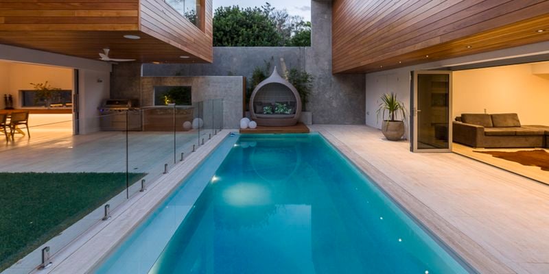 pool surrounded by timber panelled house
