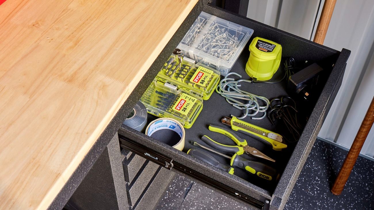 Close up image of open drawer with ryobi tools and hooks inside