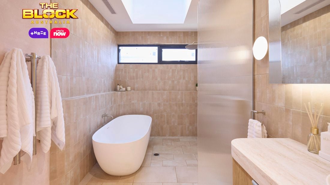 Natural coloured bathroom with a timber fluted profile vanity and marble benchtop and bath.
