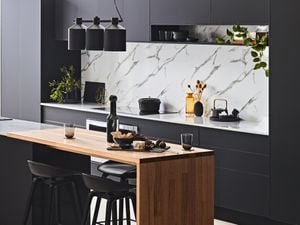 Kitchen with black benches and marble splashback.