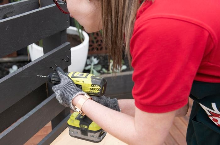 Holes being drilled into a painted pallet for utensil hooks