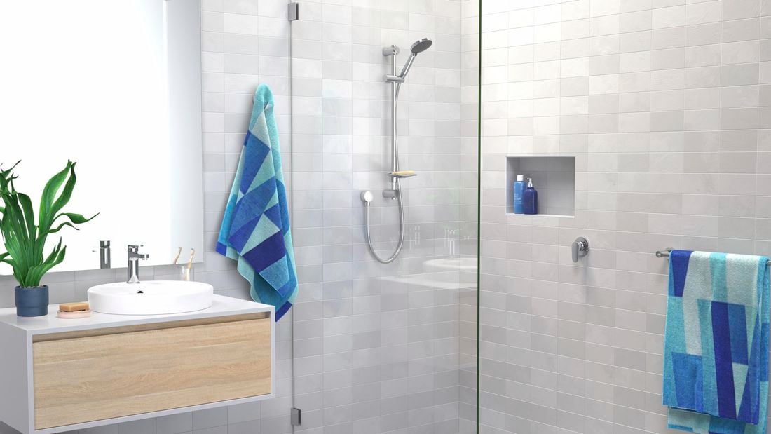 A grey bathroom with a white basin, shower and a plant in it