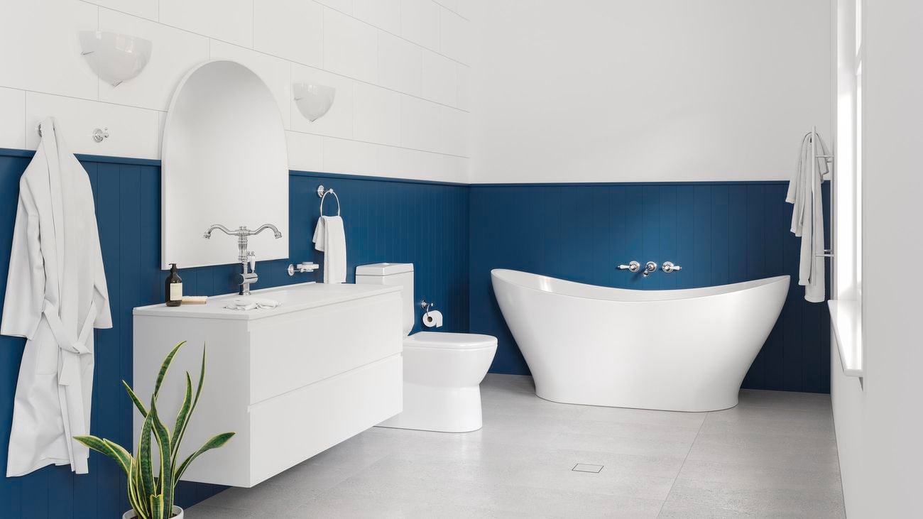 Blue water-resistant VJ panels are installed halfway up the walls in a Hamptons-style bathroom