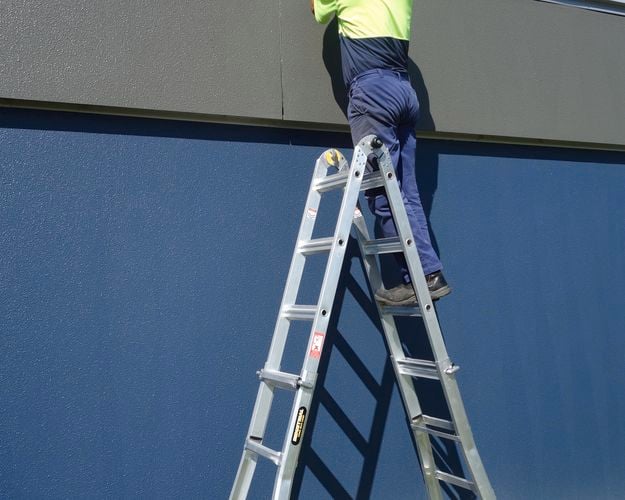 tradesperson working on a ladder
