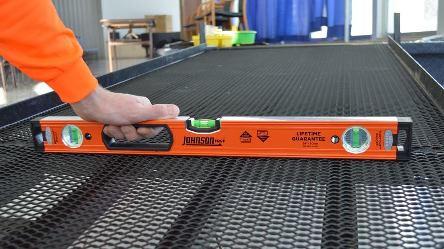 Person using box level to measure grate level
