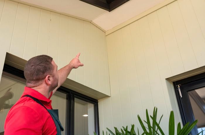 A person directing his hand to a ceiling.