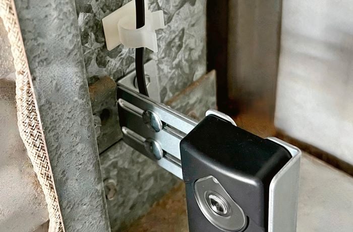 Self-adhesive cable mounts hold sensor against the wall