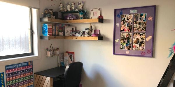 Two floating timber shelves above a desk in a home office