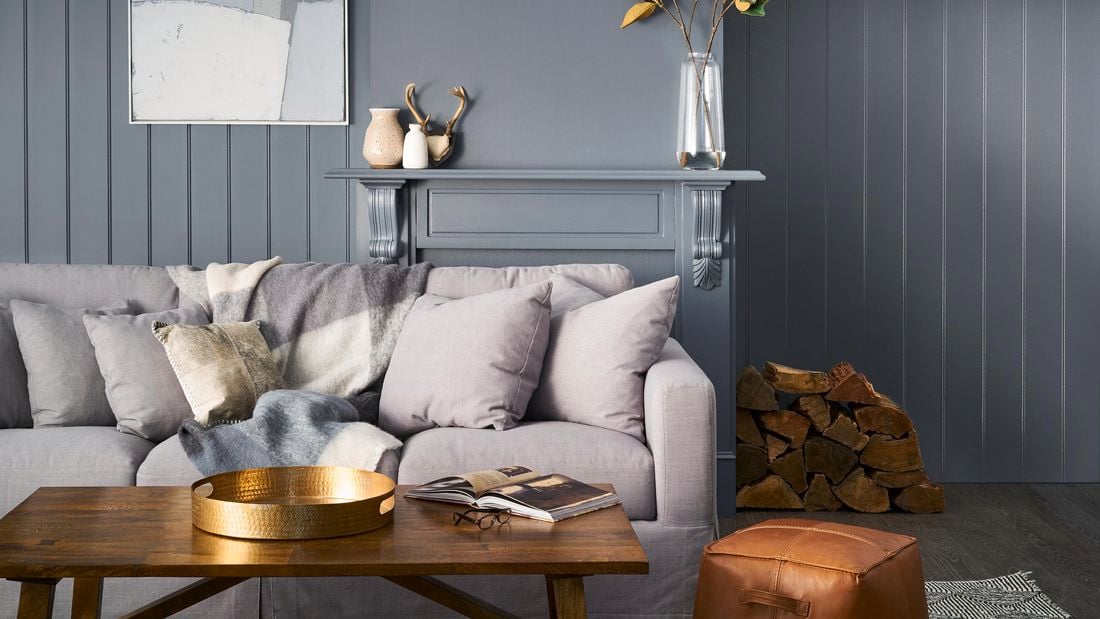 Lounge room  with grey walls, side table with vase and print hanging on the wall