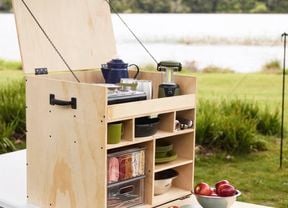 Fully assembled and kitted out camping kitchen box sitting on a tressle table ready to be used