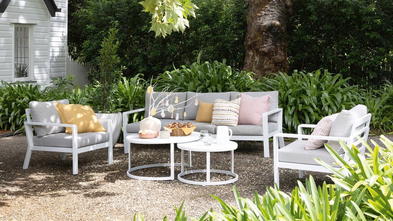 Outdoor lounge setting with a table displaying Easter craft ideas