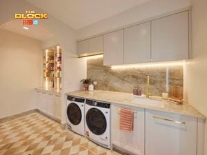 Laundry from The Block with marble splashback, under-cabinet lighting, washer and dryer, and built-in shelving.