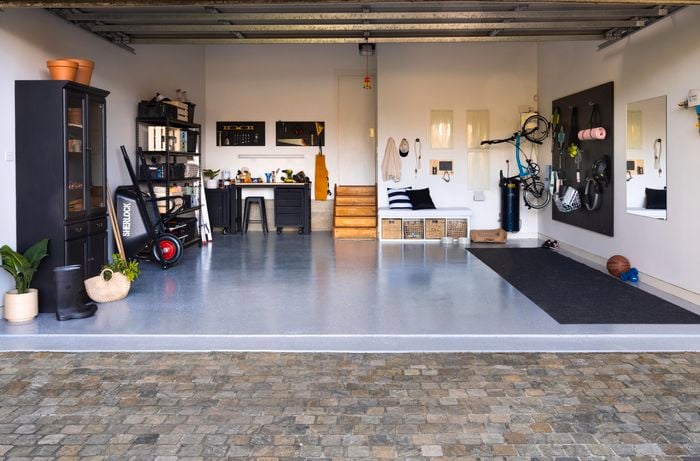 Wide shot of a garage makeover, featuring an epoxy floor, storage units and gym equipment