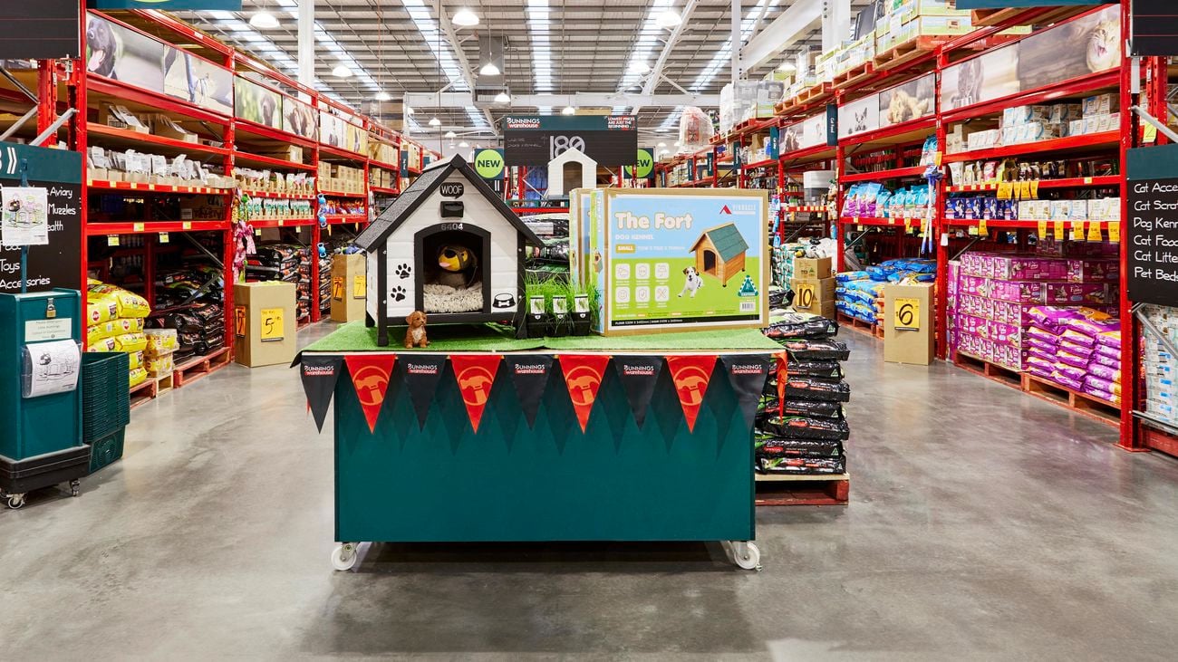 Wide shot of pet accessories in Bunnings’ aisles with new signs hanging around the store