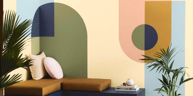 lounge with geometric feature wall, cushions and a rug