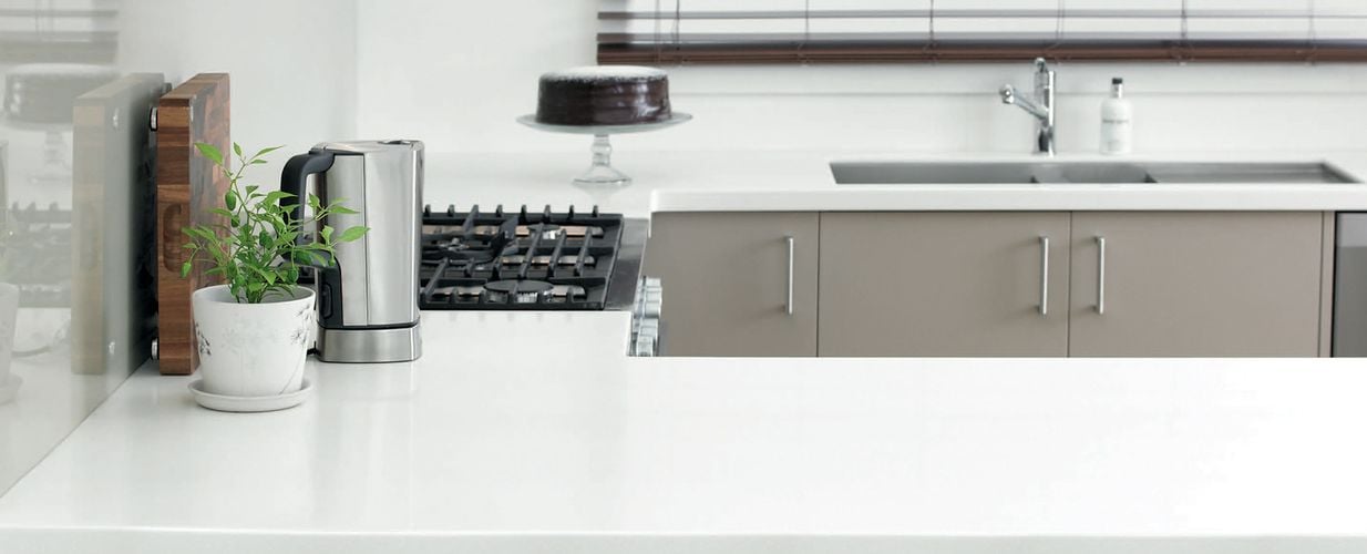 Close up of U-shaped kitchen benchtops in smooth white finish