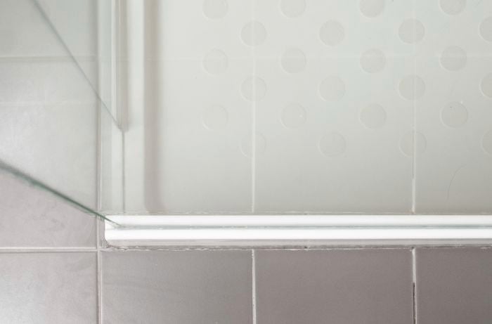 A nice and white sparkling silicone in a tiled shower.