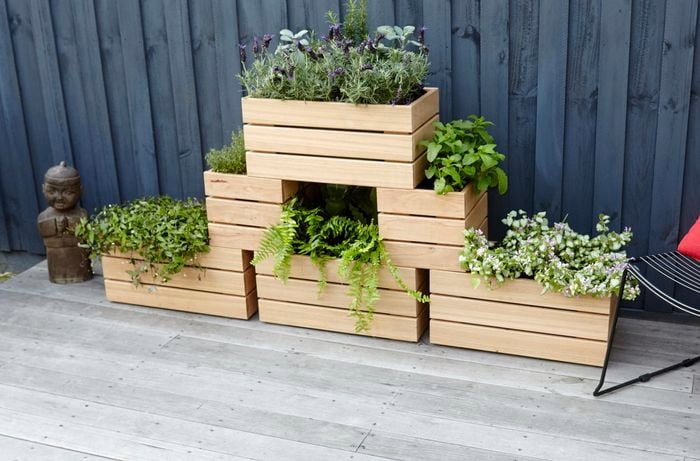 Six wooden planter boxes with plants stacked in a three-level pyramid