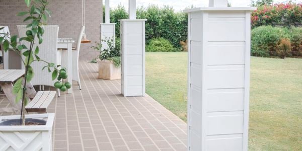White outdoor furniture in an outdoor room with white columns