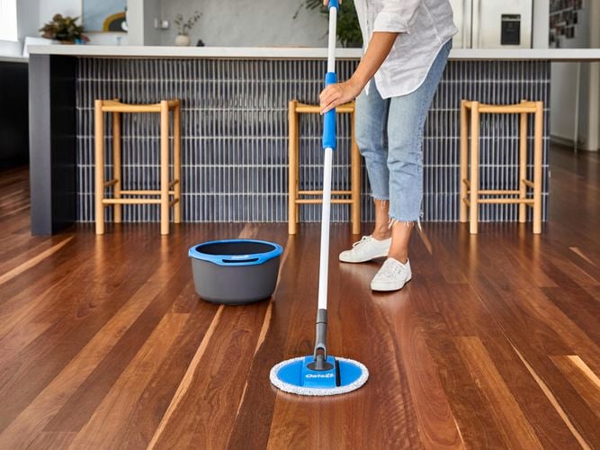 woman mopping the floor with a spin mop