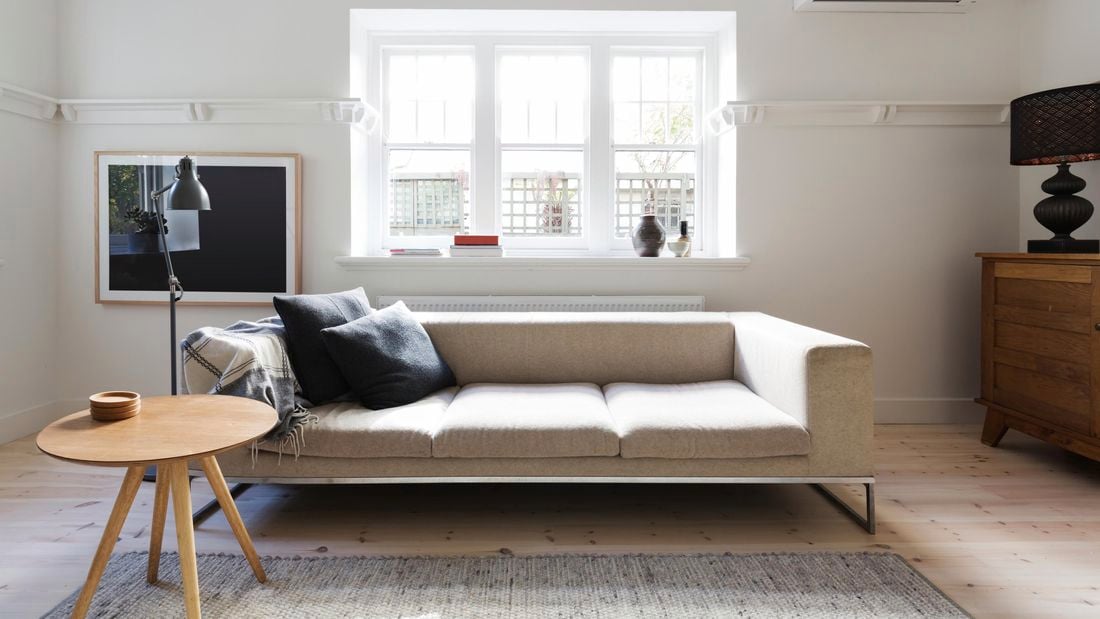 Styled living room featuring an air conditioner, beige sofa, timber coffee table and console