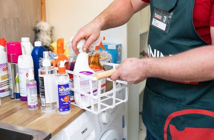 Person putting laundry items in a basket