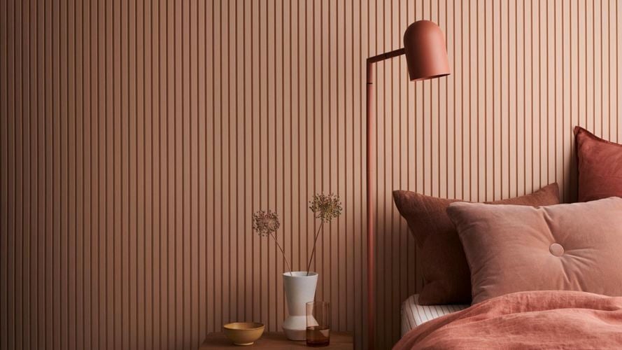 Bedroom with bed, lamp and coffee table. Batten 25 design in Dulux Clay Court.