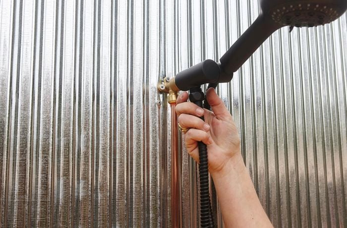 Person install black metal shower head.