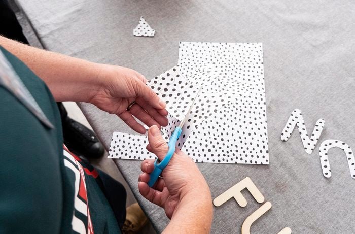 Person cutting spotted paper.