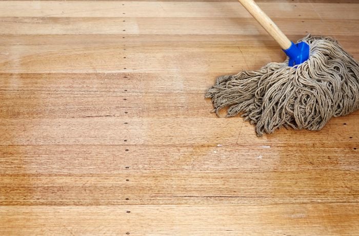 A hardwood timber floor being cleaned with a mop