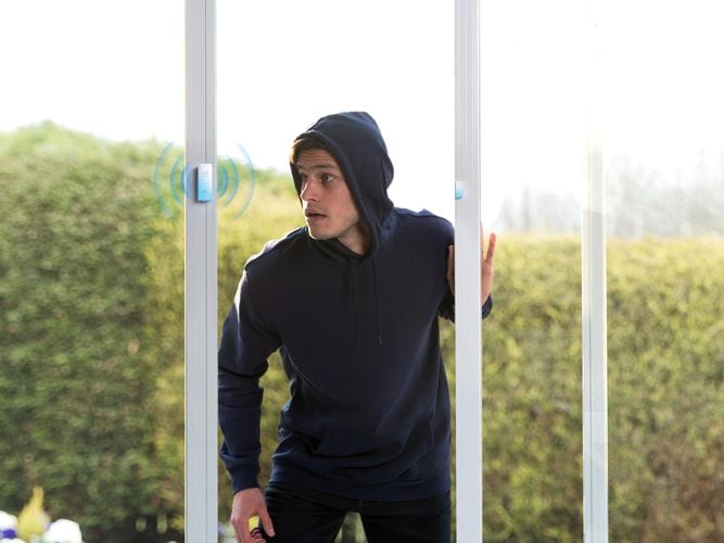 man entering a house and alarm beeping