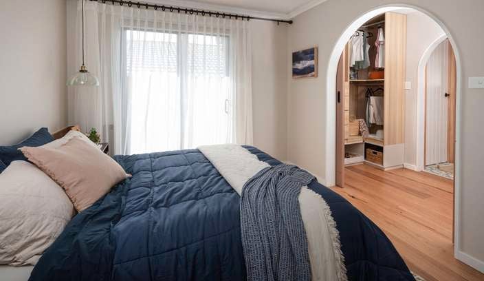 Bedroom with bed in it, a ceiling fan and a picture on the wall