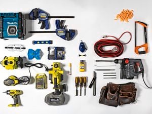 Flat-lay of various tools. These tools include a drills, sander, saw, toolbelt, earplugs, screwdrivers, power cords and clamps.