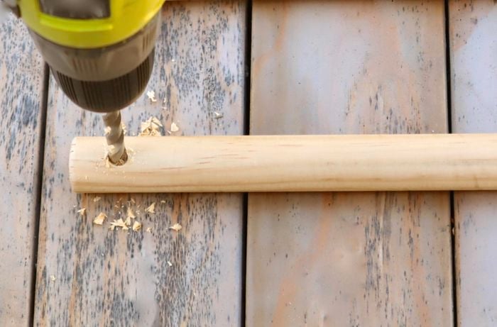 Close-up of a person drilling a hole in a dowel rod