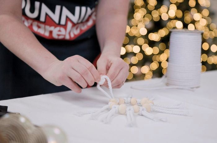 A Bunnings Team Member holding a cord on a macrame decoration