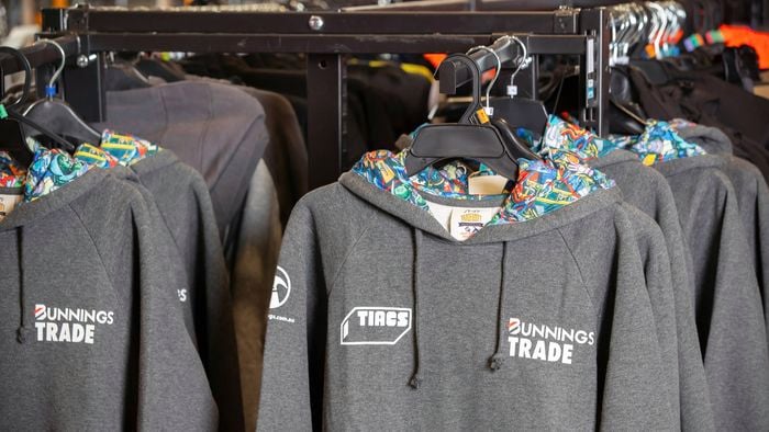 Multiple TIACS grey hoodies hanging on a coat rack.
