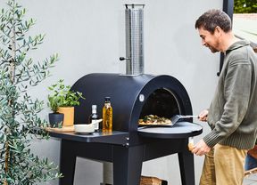 Pizza oven being used by man