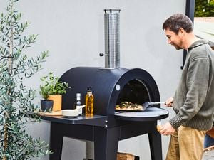 Pizza oven being used by man