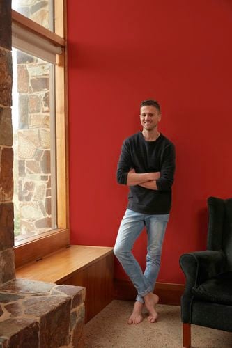 Man stands next to wall that was painted red using a chilli as reference