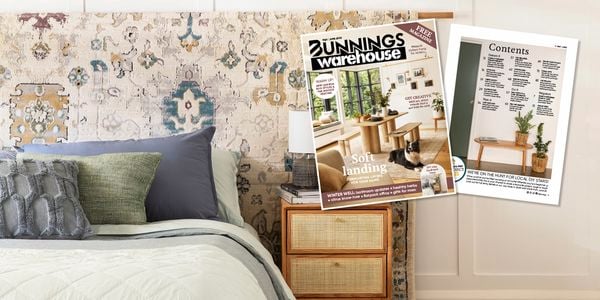 A bed with cushions and hanging rug with magazine overlay.
